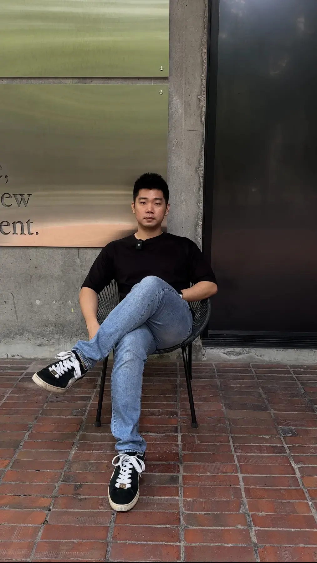 Adrian Ching seated outside a studio